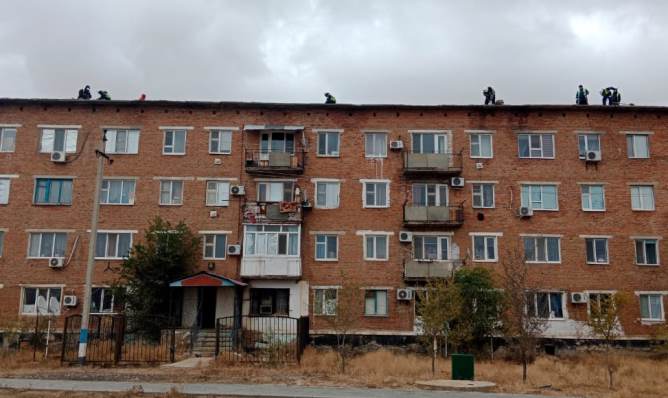 The roof and facade of an apartment building in the village of Makat are being repaired