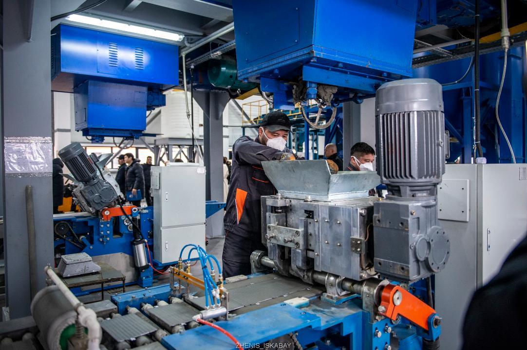 Зауыт жұмысшылары жұмыс үстінде