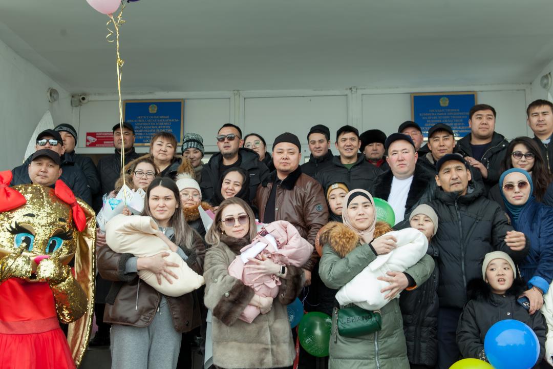 Родные и близкие выписывают молодую женщину с детьми с роддома
