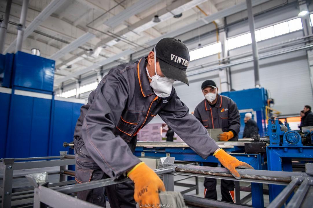 Зауыт жұмысшылары жұмыс үстінде