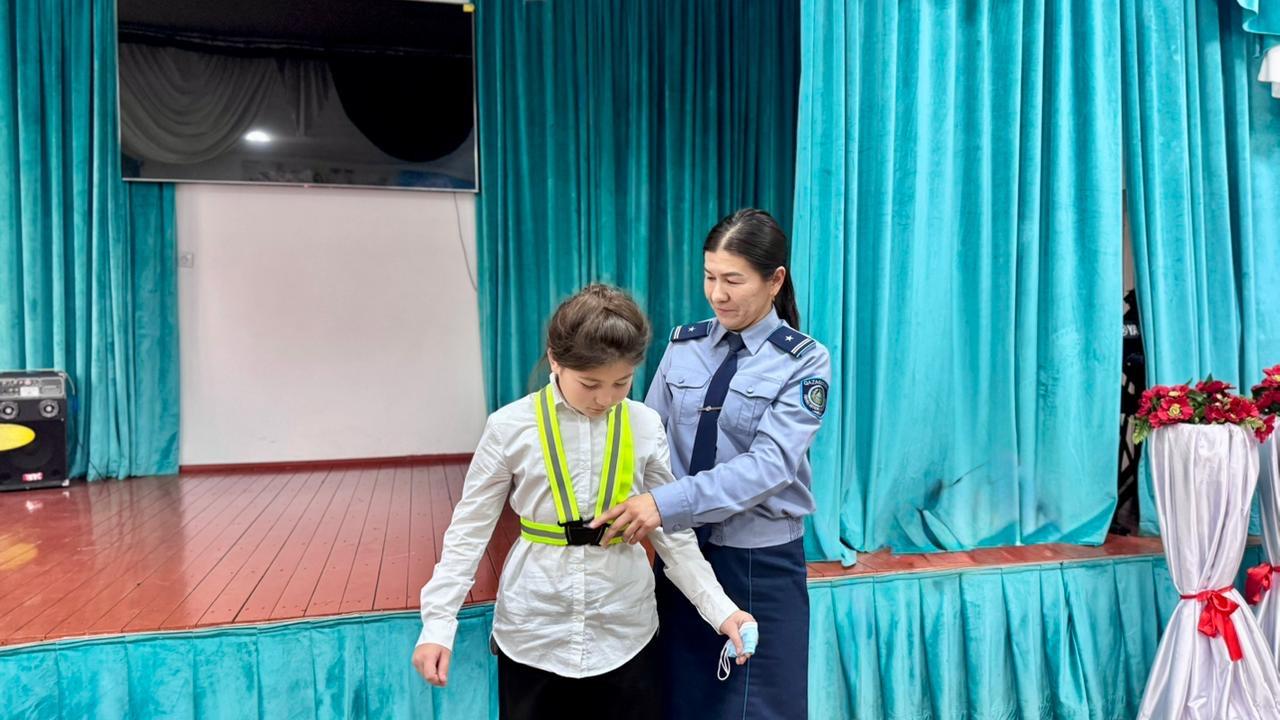 Сотрудник полиции объясняет, как надевать светоотражающий жилет