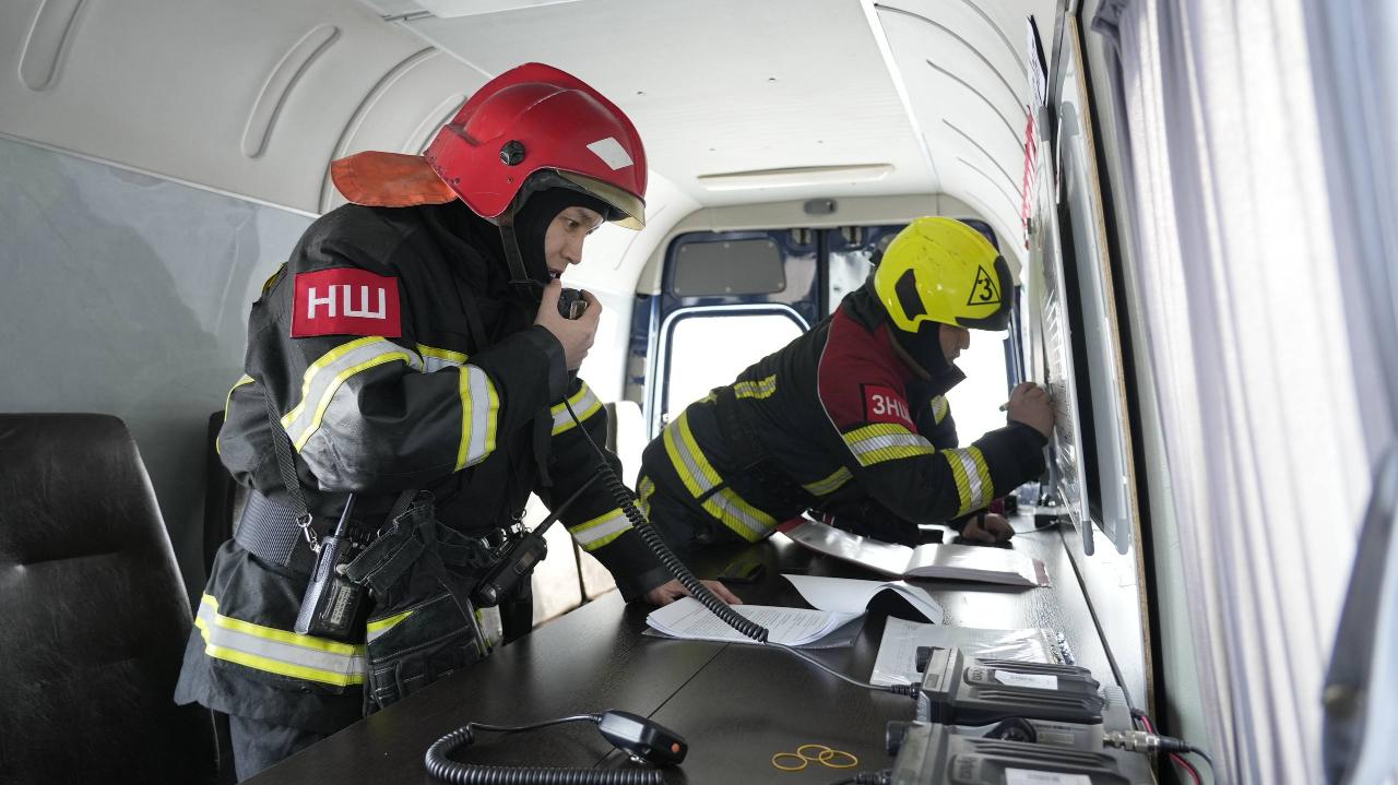 Төтенше жағдай қызметкерлері көлікте отырып, байланыс құралы арқылы хабарласып жатыр.